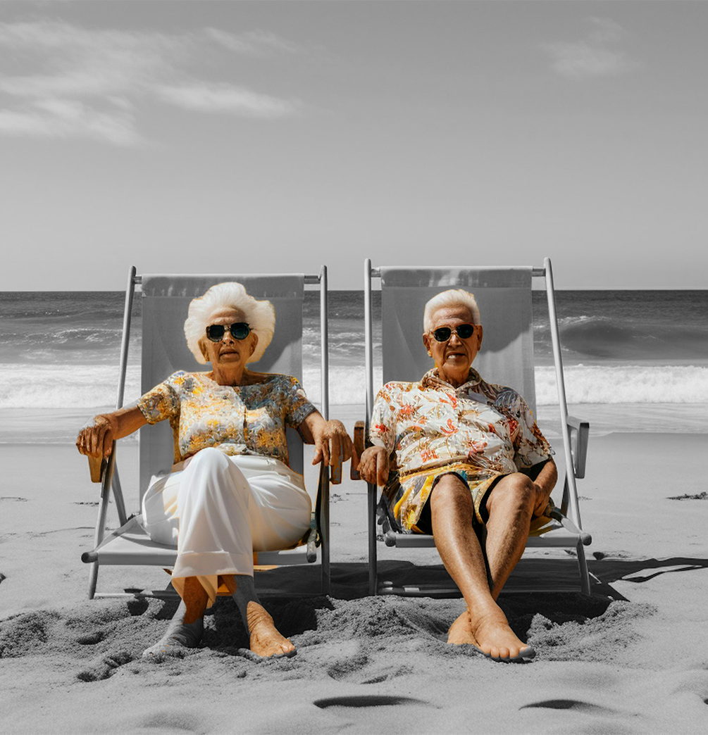 Un couple de retraités assis sur des chaises longues à la plage.